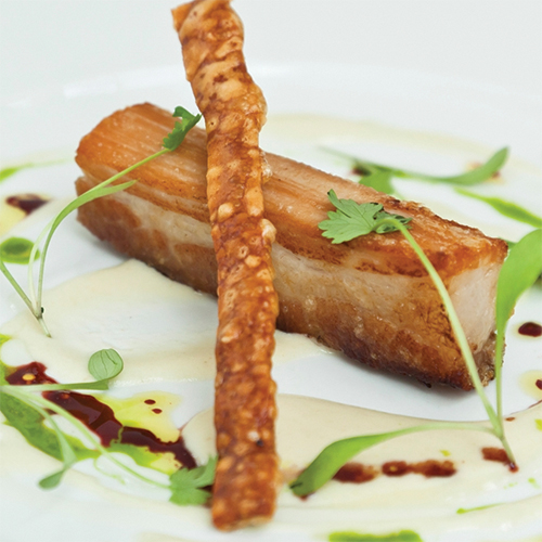 Slow braised pork belly with apple soup, garlic purée and Port jus
